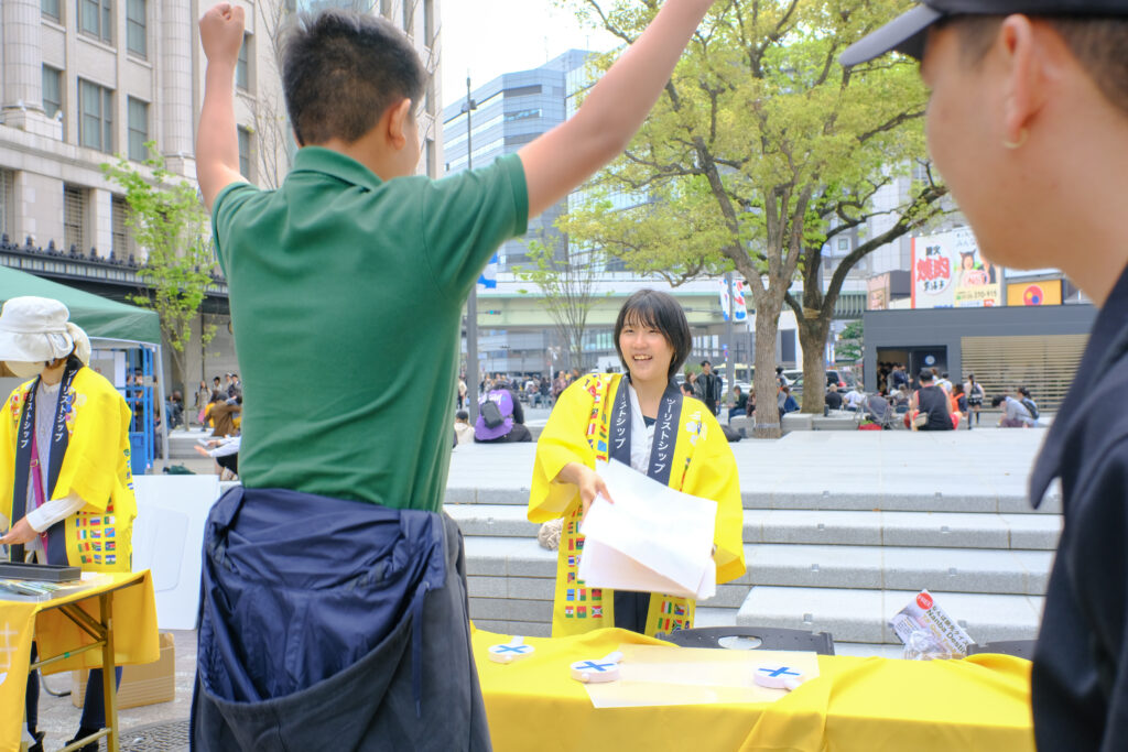 なんば広場イベント「なんば旅先クイズ会」でクイズに挑戦し、正解して喜ぶ外国人観光客
