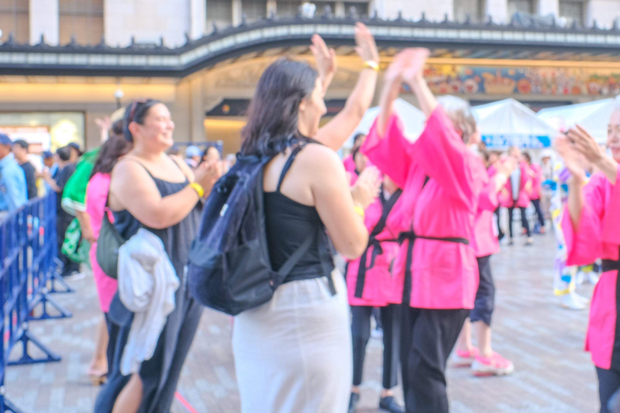 「大阪ミナミ夏祭り＆にぎわいスクエア2025」の盆踊りで外国人観光客と地元の方がハイタッチをする様子